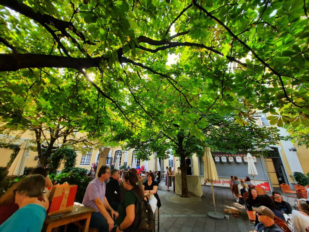 Der schattige biergarten der stieglbrauwelt salzburg unter kastanienbäumen